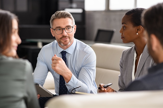 Mature executive meets with senior leaders in an informal setting