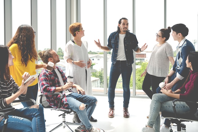 A young Black woman leads her team in a project meeting