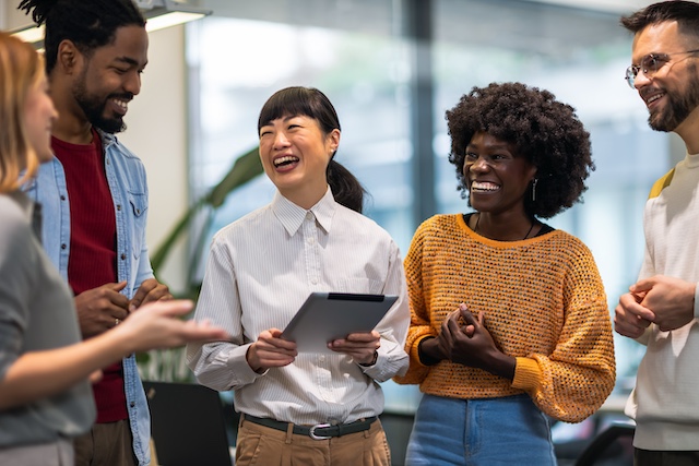 A diverse group of employees laughing together