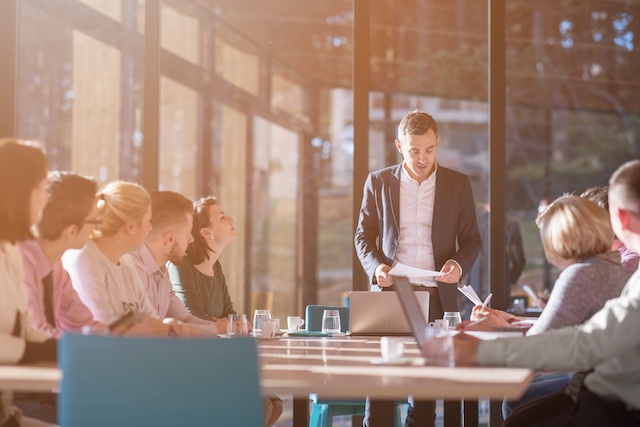 Young male leader heads a meeting in a conference room