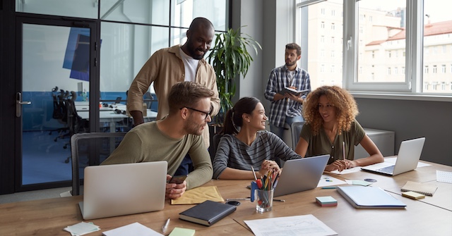 A young Black woman leads her team in a project meeting