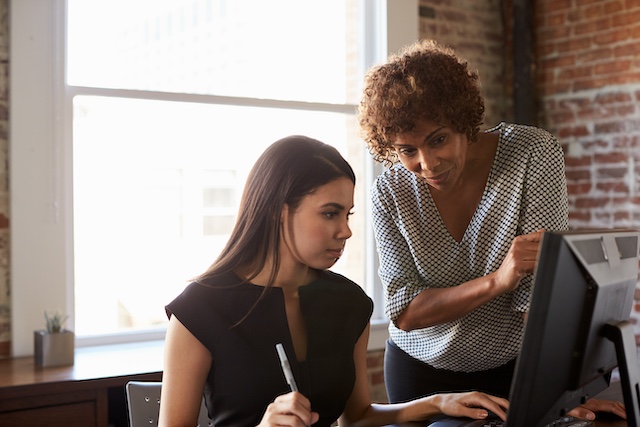 A Black female manager mentors a younger female employee