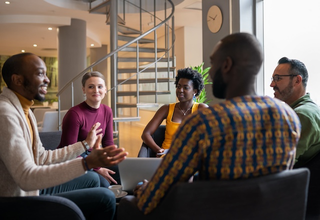 A diverse group of employees meet in a casual setting